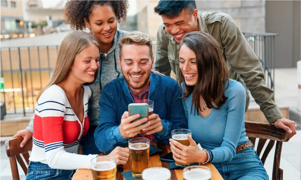 In-Person GPS Games 10 Pub Explorer team around a phone with beers on the table